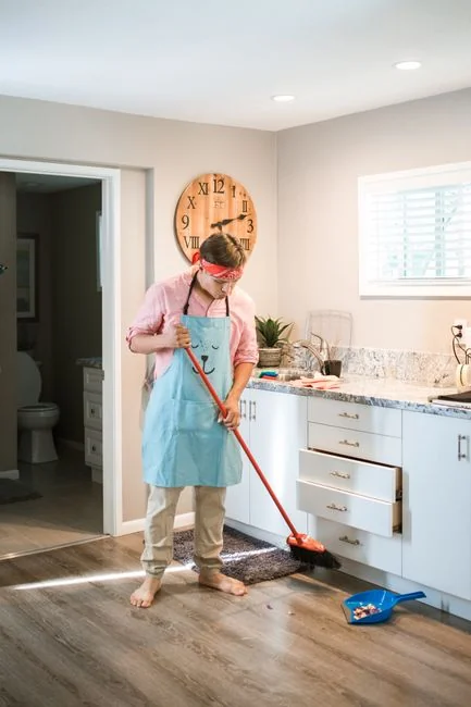 A modern kitchen undergoing renovation, featuring a worker, tools, and materials.